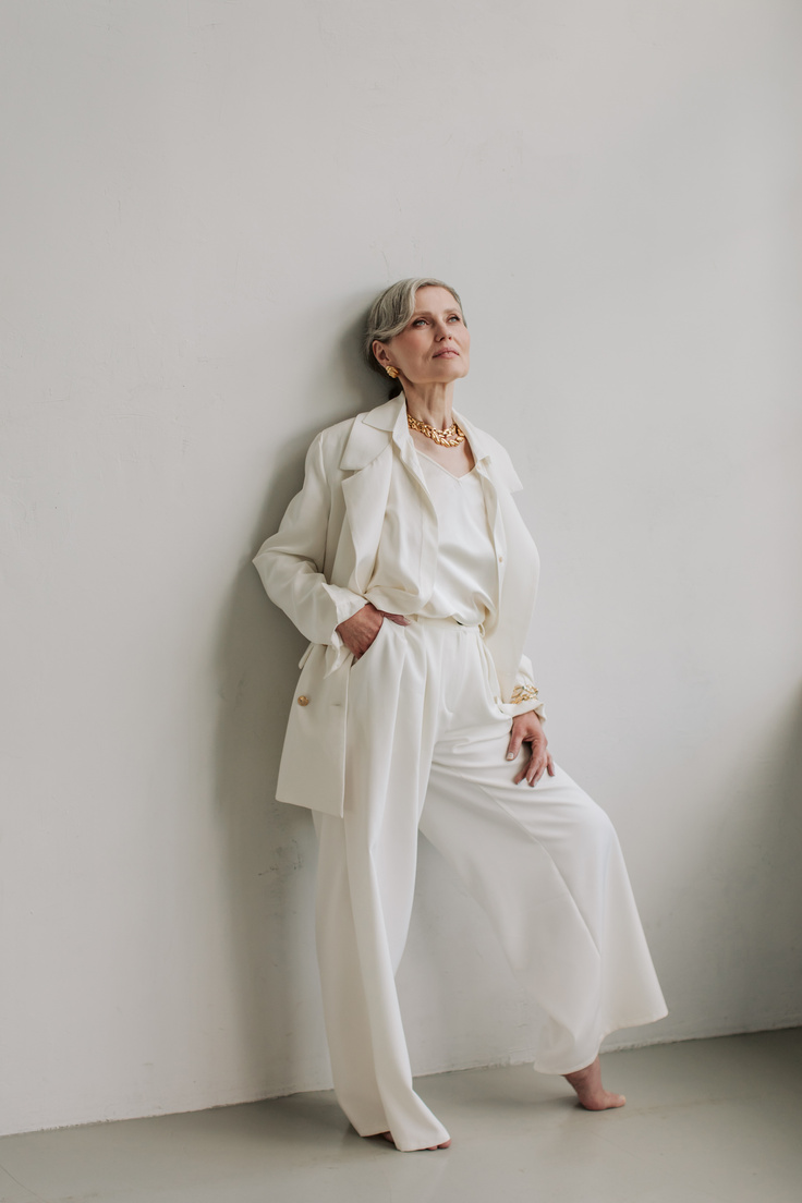 Elegant Old Woman in White Outfit and Gold Accessories