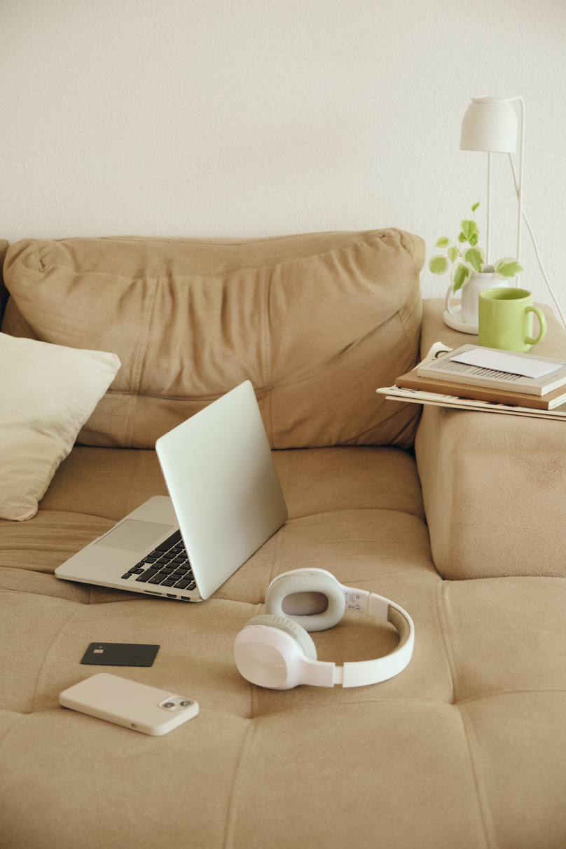 Laptop, Headphones, Smartphone, and Credit Card on the Sofa